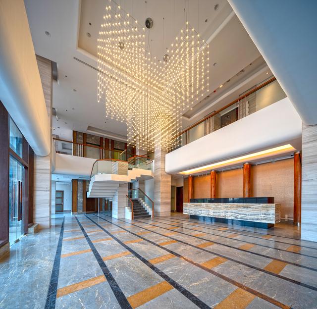 Contemporary chandelier installed in a luxury hotel lobby.