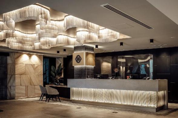 Contemporary chandelier installed in a luxury hotel lobby.