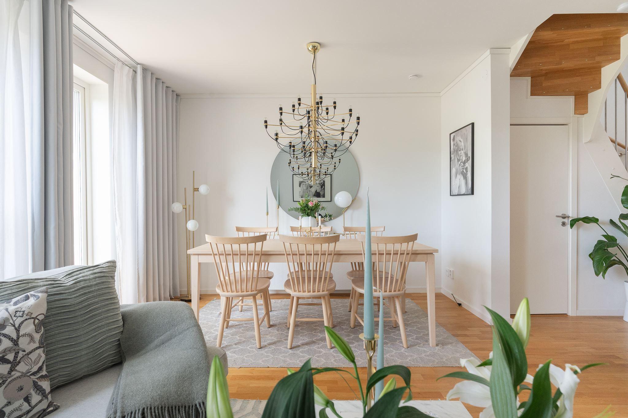 Scandinavian chandelier installed above a contemporary dining area in a modern residential interior.