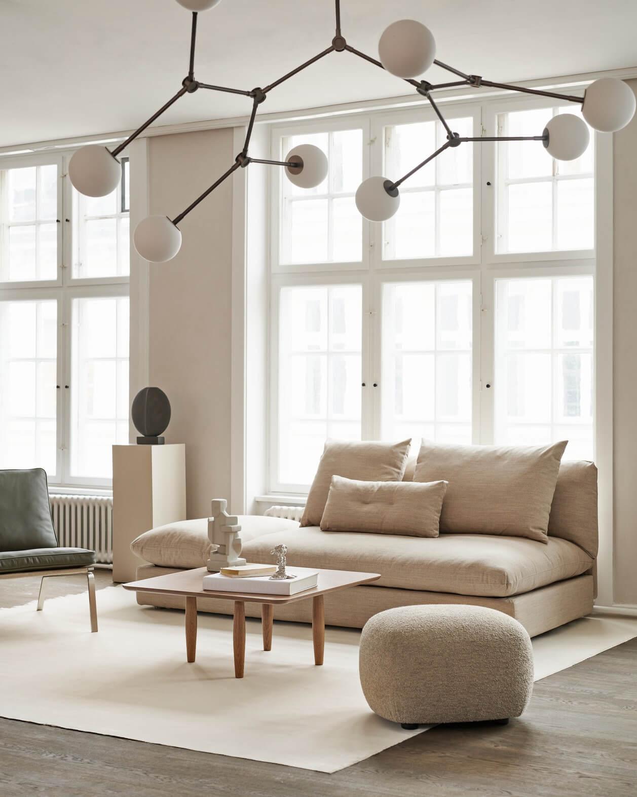 Scandinavian chandelier installed above a contemporary dining area in a modern residential interior.
