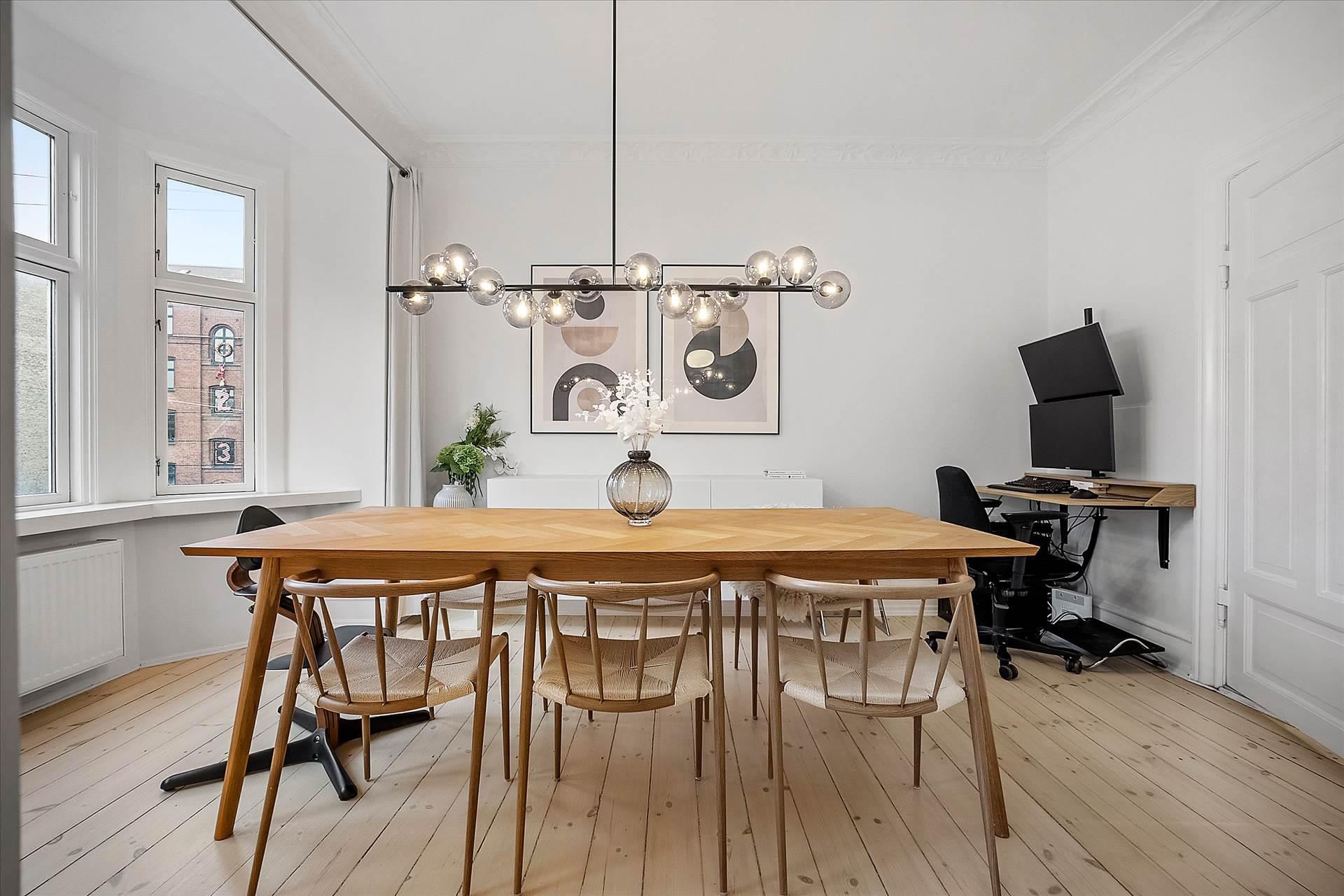 Scandinavian chandelier installed above a contemporary dining area in a modern residential interior.