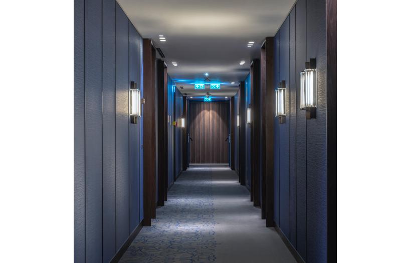 Custom wall lighting installed in a luxury hospitality project with distinctive architectural detailing.