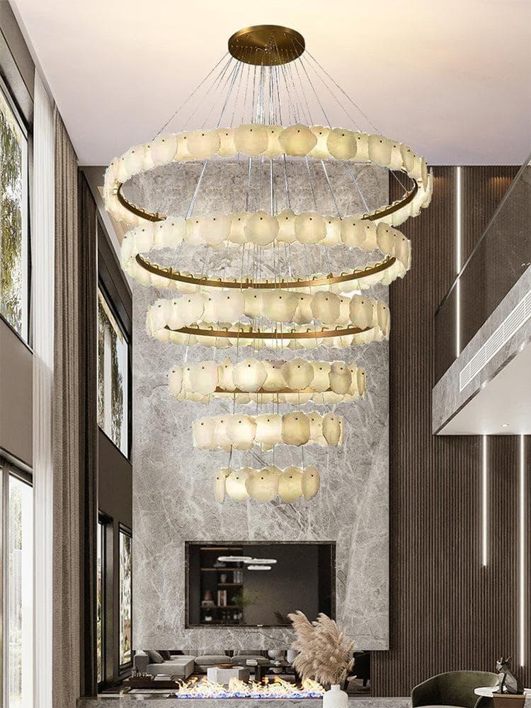 Luxury marble chandelier installed above a dining table in a contemporary hospitality interior, creating a refined architectural focal point.