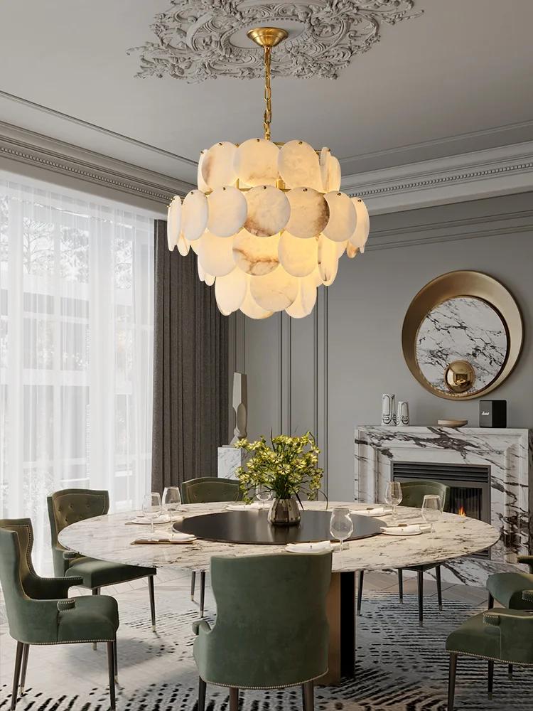 Luxury marble chandelier installed above a dining table in a contemporary hospitality interior, creating a refined architectural focal point.