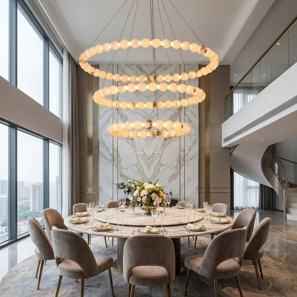 Luxury marble chandelier installed above a dining table in a contemporary hospitality interior, creating a refined architectural focal point.