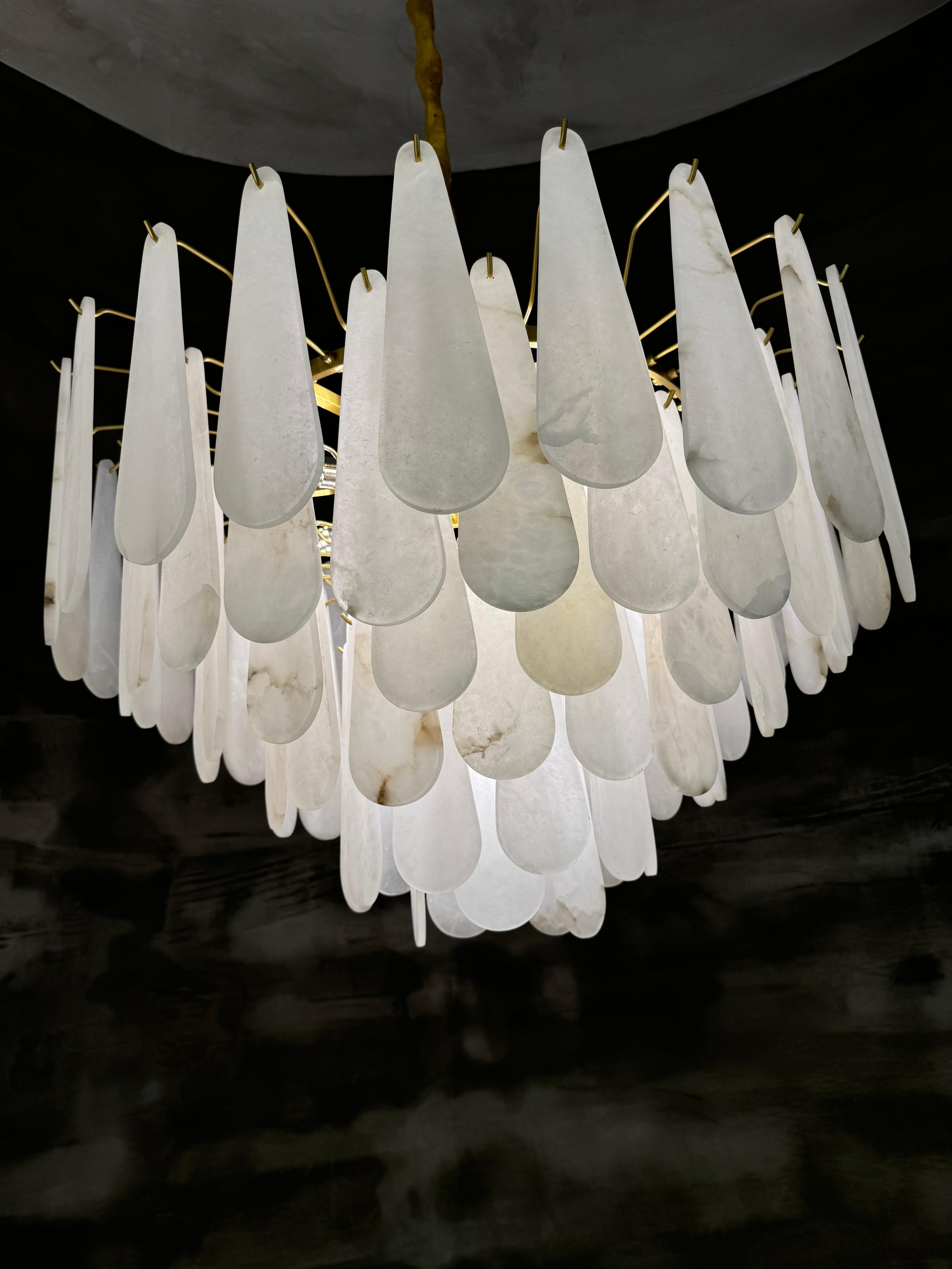 Luxury marble chandelier installed above a dining table in a contemporary hospitality interior, creating a refined architectural focal point.