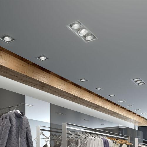 Multiple recessed downlights installed in a contemporary retail interior.