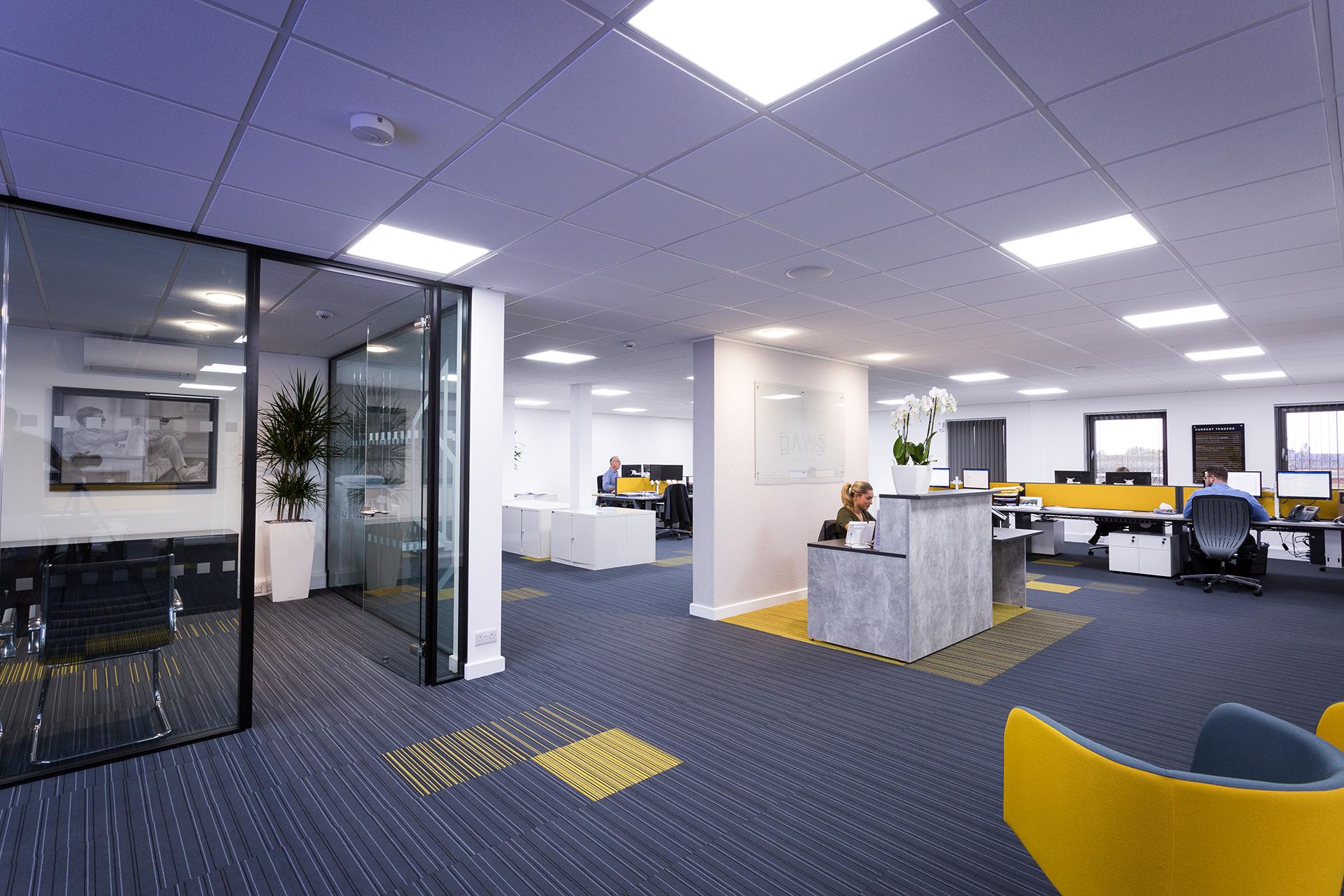 Low-glare recessed panel lighting providing comfortable illumination across a modern open-plan office
