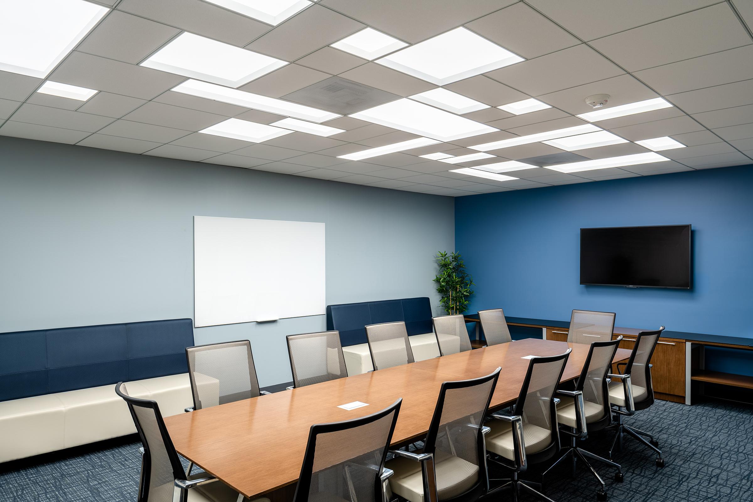 Recessed low-glare panel lighting creating a comfortable visual environment in a contemporary office meeting space