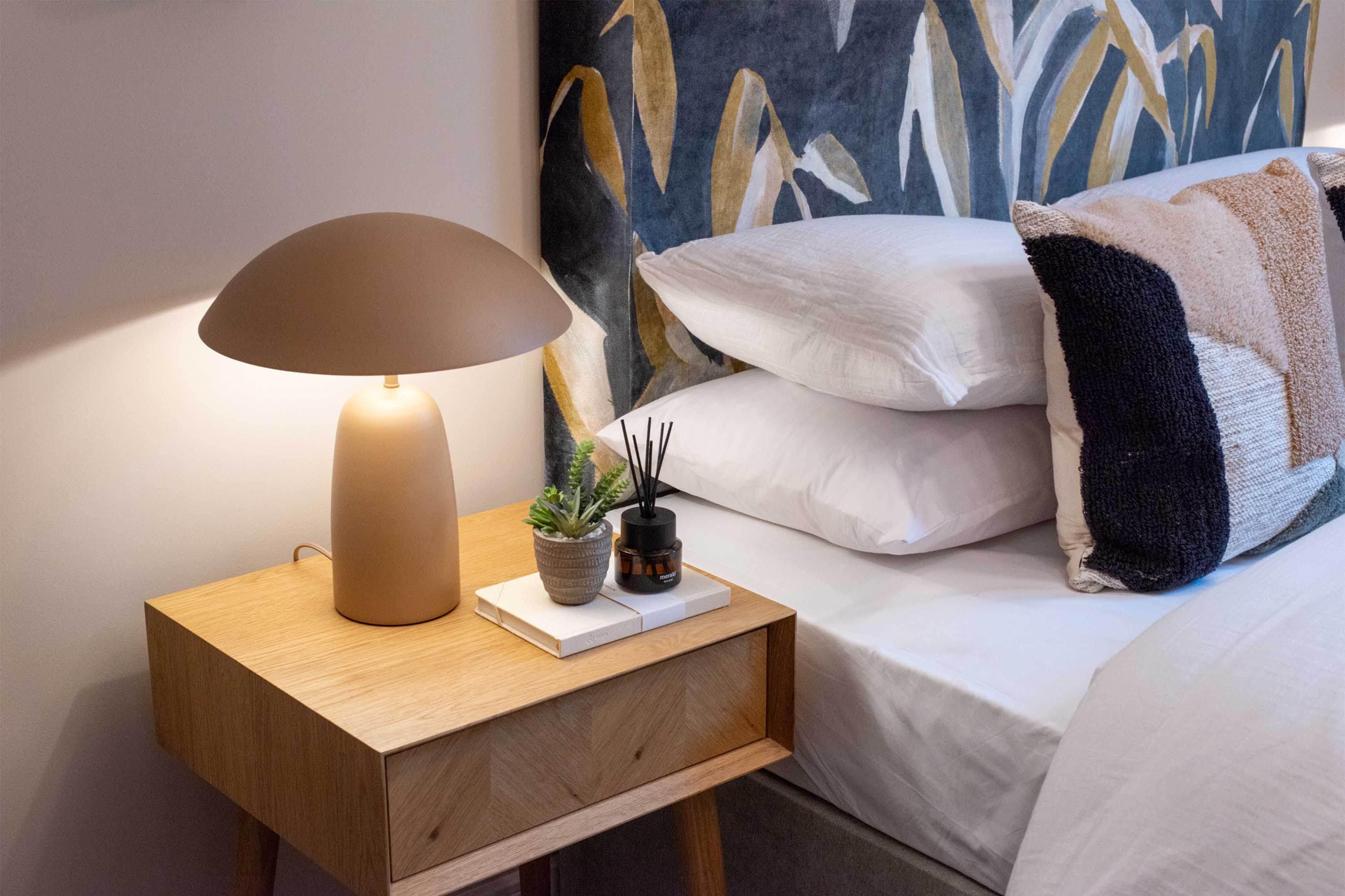 Bedside table lamp placed on a nightstand in a luxury hotel suite creating comfortable ambient lighting for evening use.