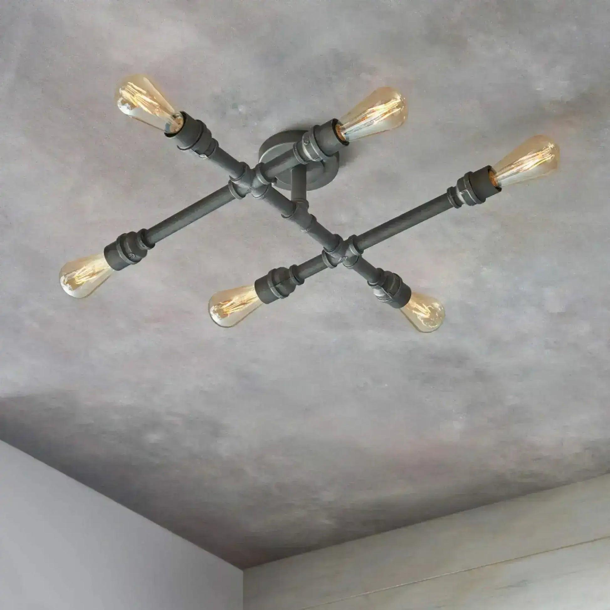 A pipe-based decorative ceiling light combining exposed metal fittings with warm filament bulbs.