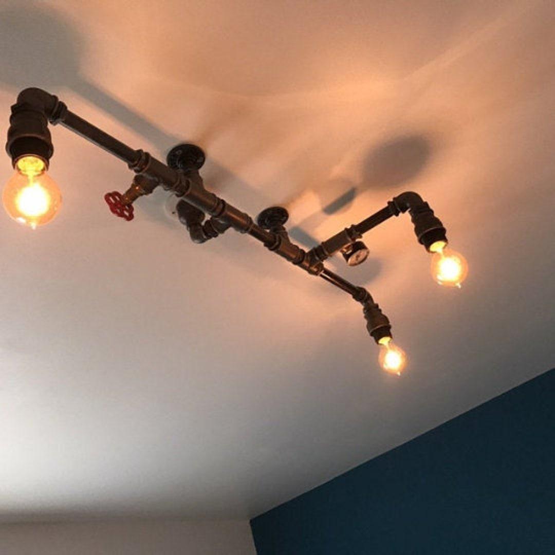 A pipe-based decorative ceiling light combining exposed metal fittings with warm filament bulbs.