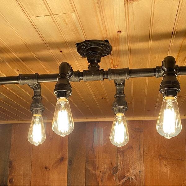 A pipe-based decorative ceiling light combining exposed metal fittings with warm filament bulbs.