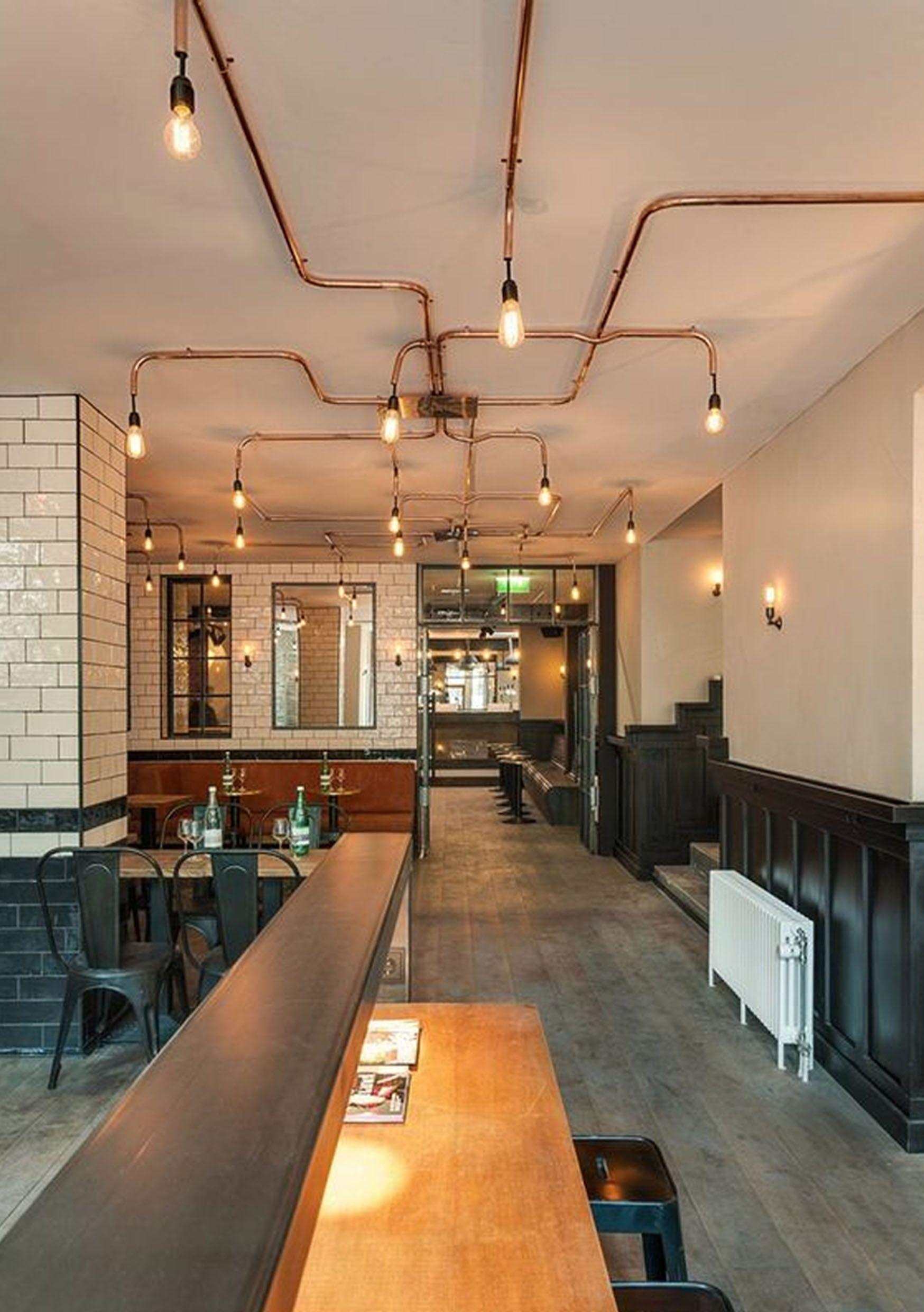 A pipe-based decorative ceiling light combining exposed metal fittings with warm filament bulbs.
