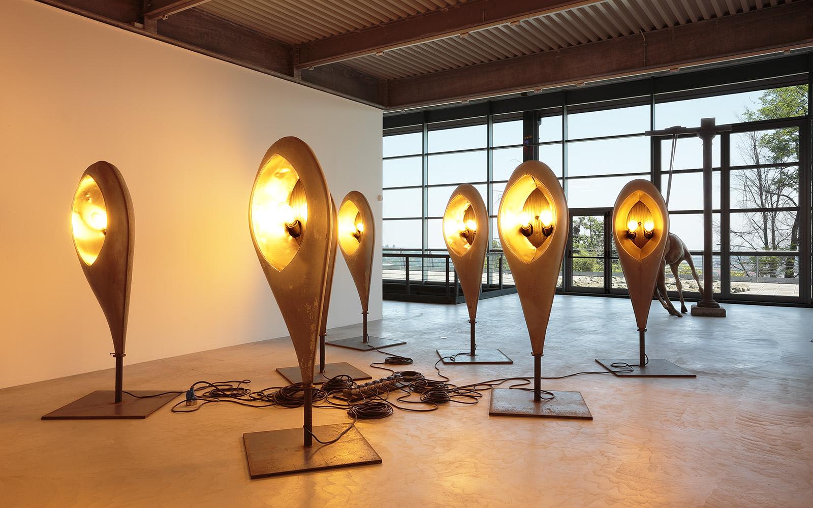 Sculptural floor lamp positioned in a luxury hotel lobby creating a dramatic architectural focal point with warm ambient illumination.