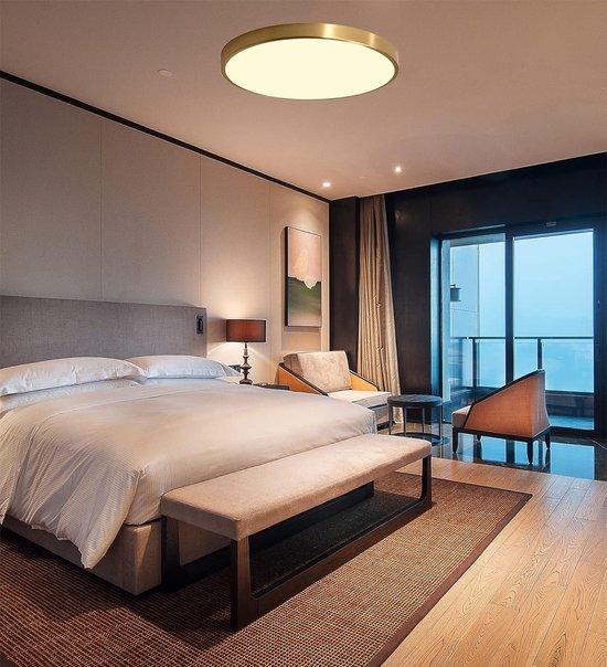Minimal ceiling-mounted decorative light integrated into a contemporary hospitality interior providing soft ambient illumination.