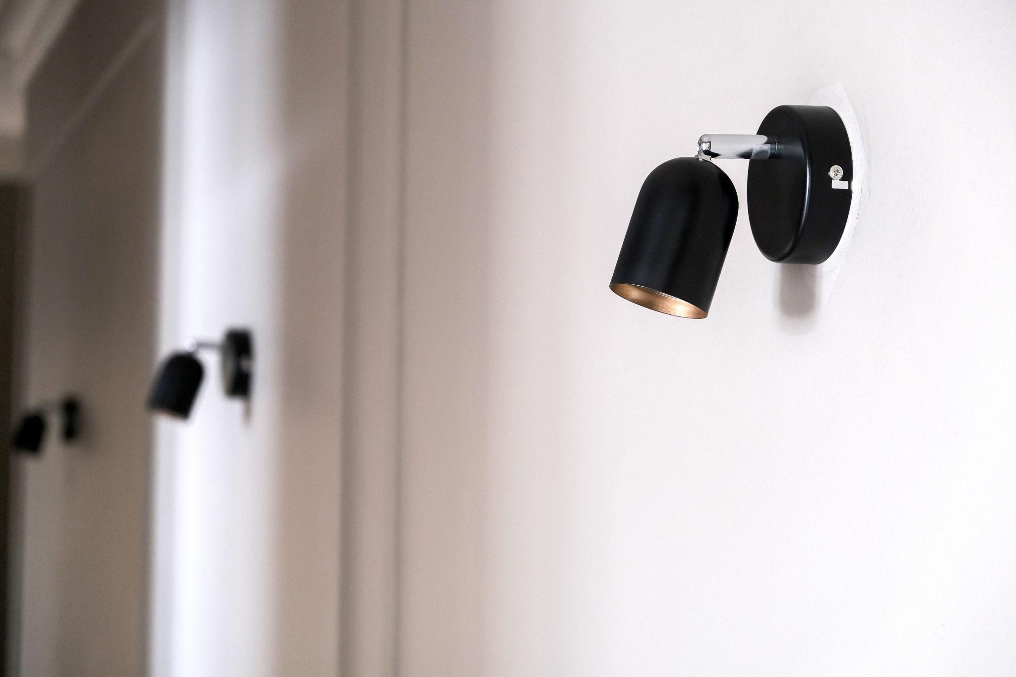 Modern wall lamp installed in a luxury hospitality interior with refined architectural detailing.