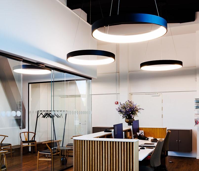 Ring pendant lighting installed in a modern office lobby.