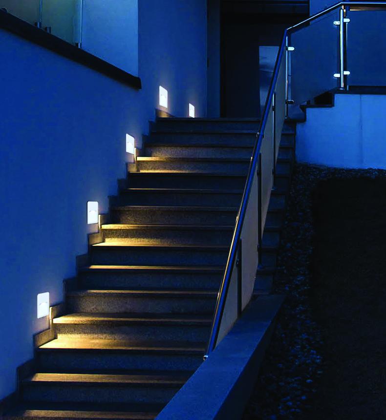 Surface-mounted step lights installed on a contemporary staircase in a public outdoor environment.