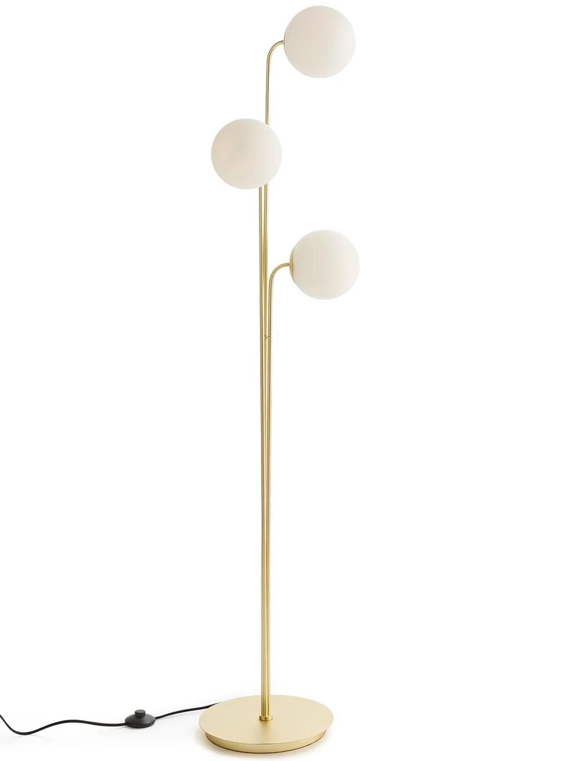 Globe floor lamp photographed on a clean white background showcasing an opal glass sphere and premium metal structure.