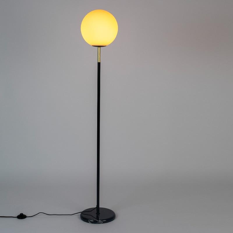 Front view of a globe floor lamp highlighting its elegant spherical diffuser and refined architectural proportions.