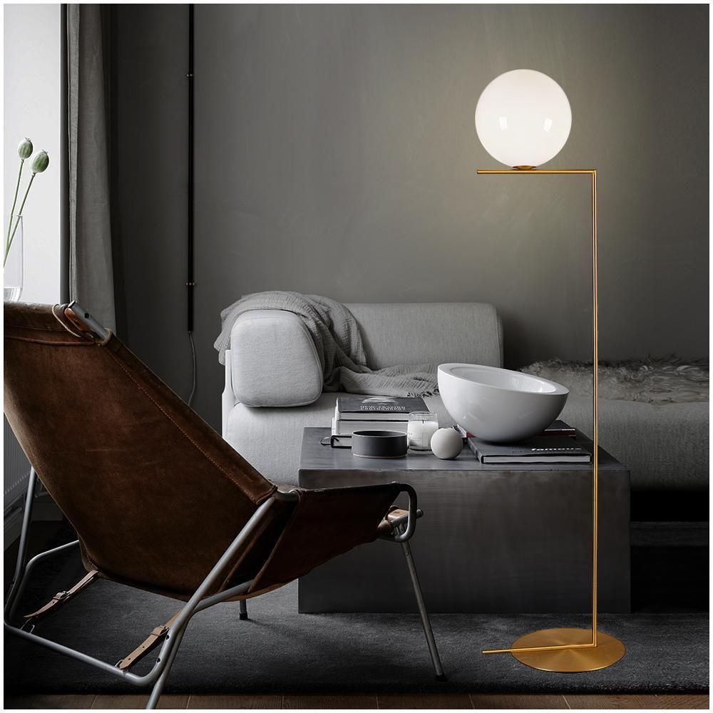 Globe floor lamp positioned beside a seating area in a luxury hotel lounge, creating soft ambient architectural lighting.