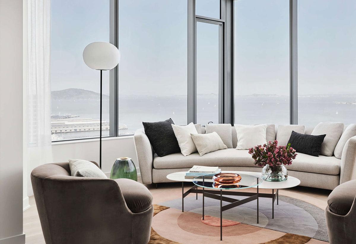 Globe floor lamp positioned beside a seating area in a luxury hotel lounge, creating soft ambient architectural lighting.