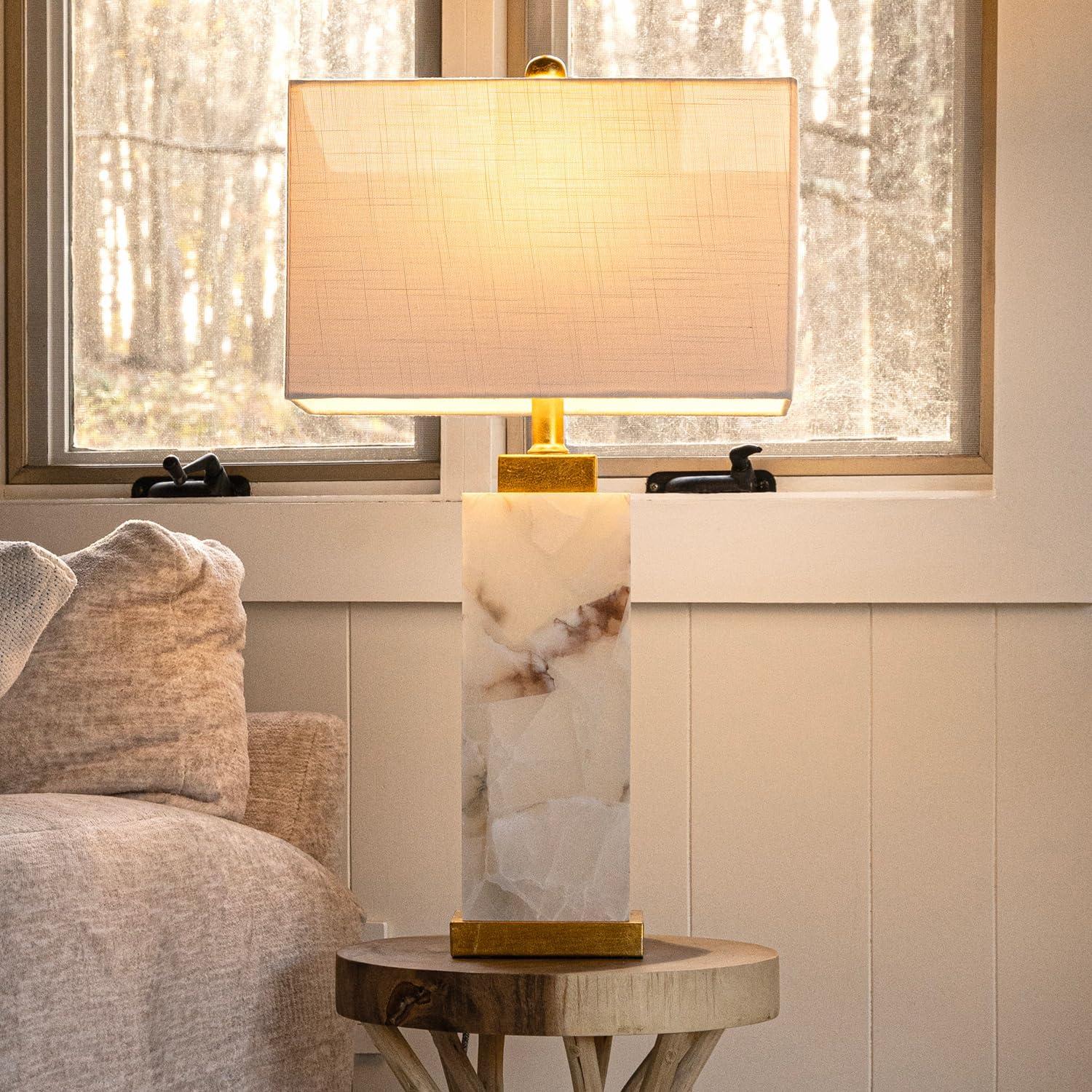 Marble table lamp placed on a bedside table in a luxury hotel suite creating warm ambient lighting and refined architectural elegance.