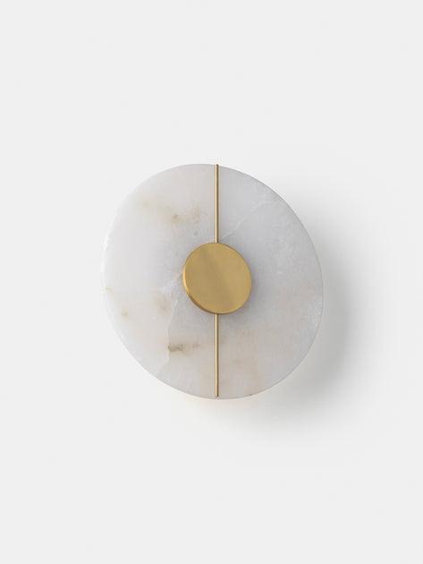Front view of a luxury marble wall lamp highlighting the unique stone veining and refined architectural design.