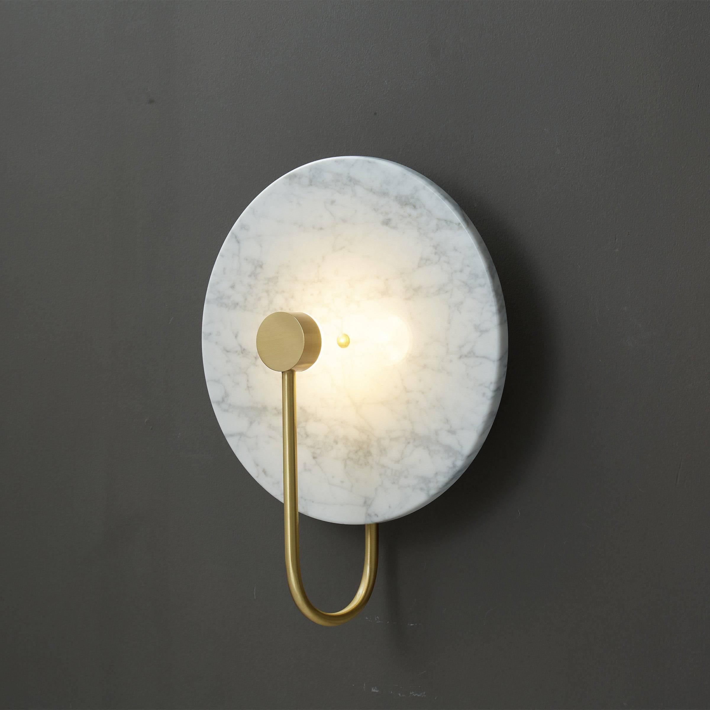 Front view of a luxury marble wall lamp highlighting the unique stone veining and refined architectural design.