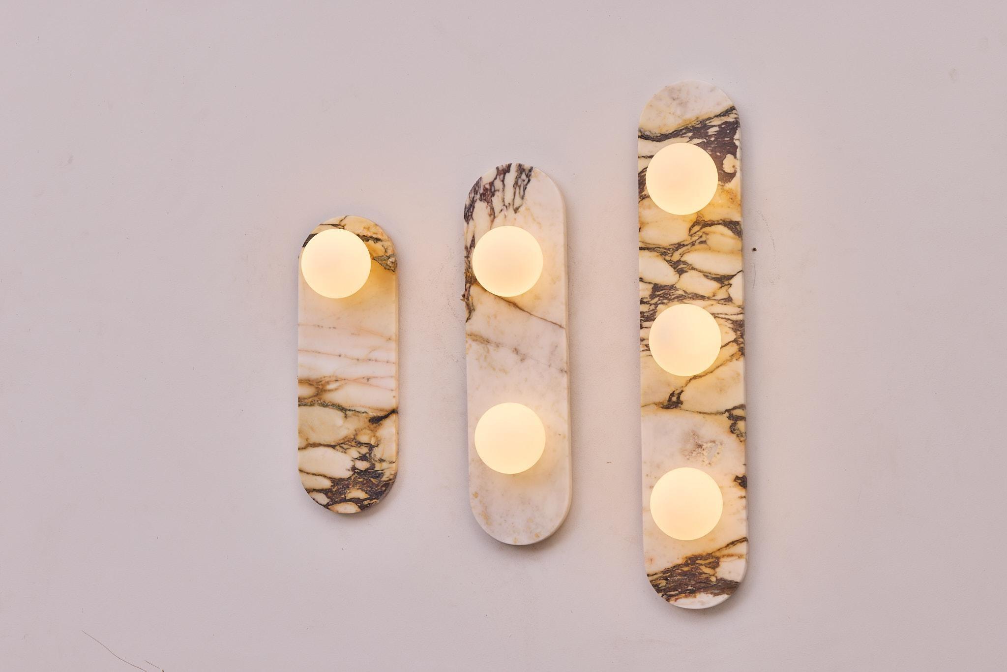 Marble wall lighting collection presenting contemporary natural stone wall lamps for premium residential and hospitality interiors.