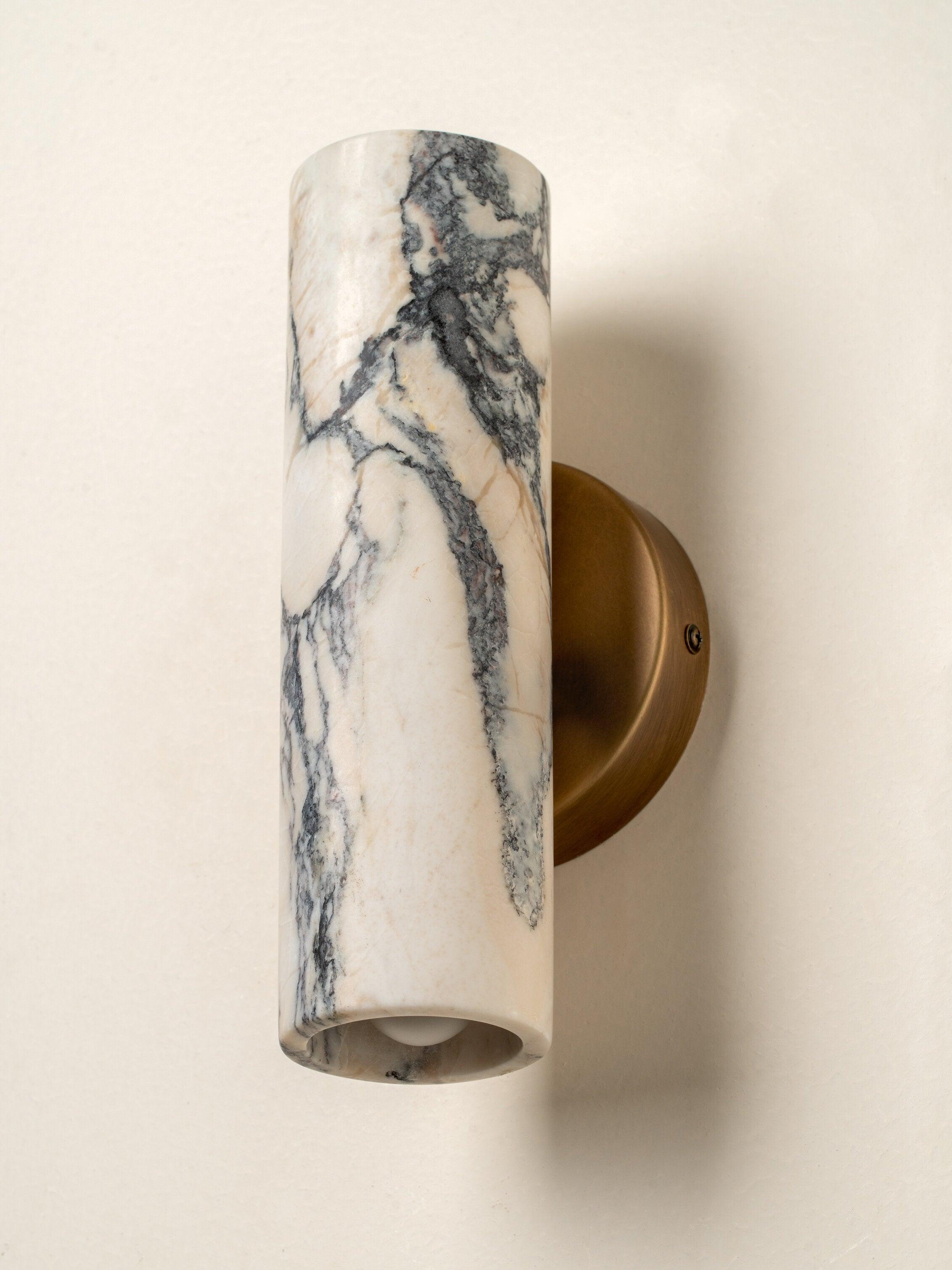 Front view of a luxury marble wall lamp highlighting the unique stone veining and refined architectural design.