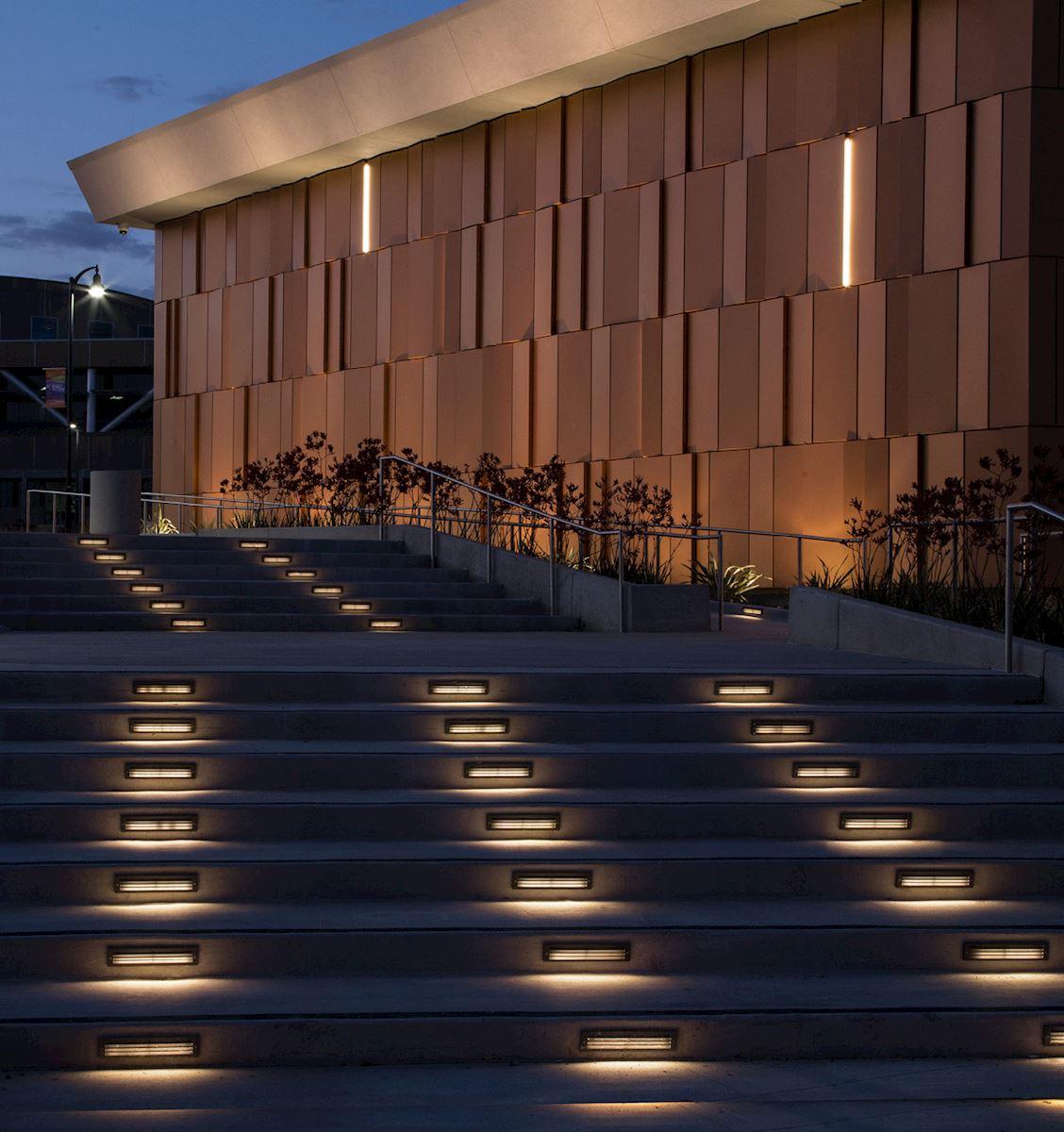 Linear step lights installed on a contemporary outdoor staircase in a hospitality landscape.