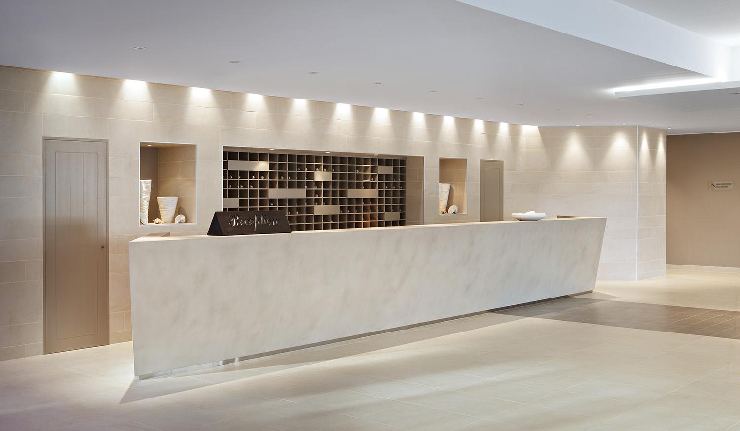 Recessed wall washers providing uniform vertical illumination in a contemporary hospitality interior.