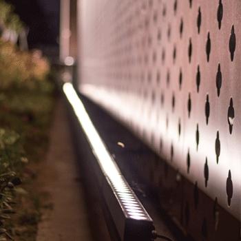 Grazer wall washers highlighting the texture of a contemporary architectural façade.