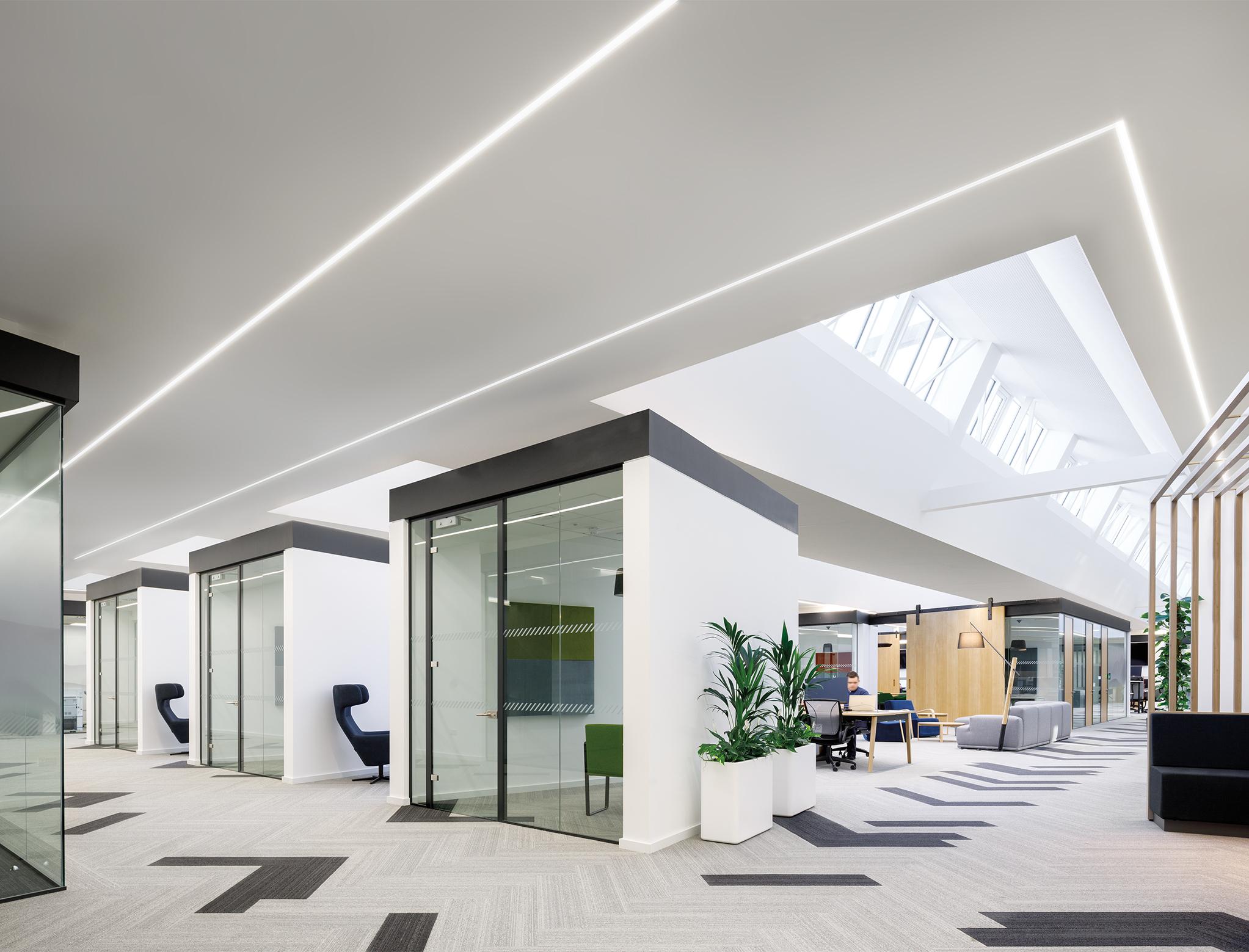 Perimeter cove lighting integrated around the ceiling perimeter of a contemporary office interior.