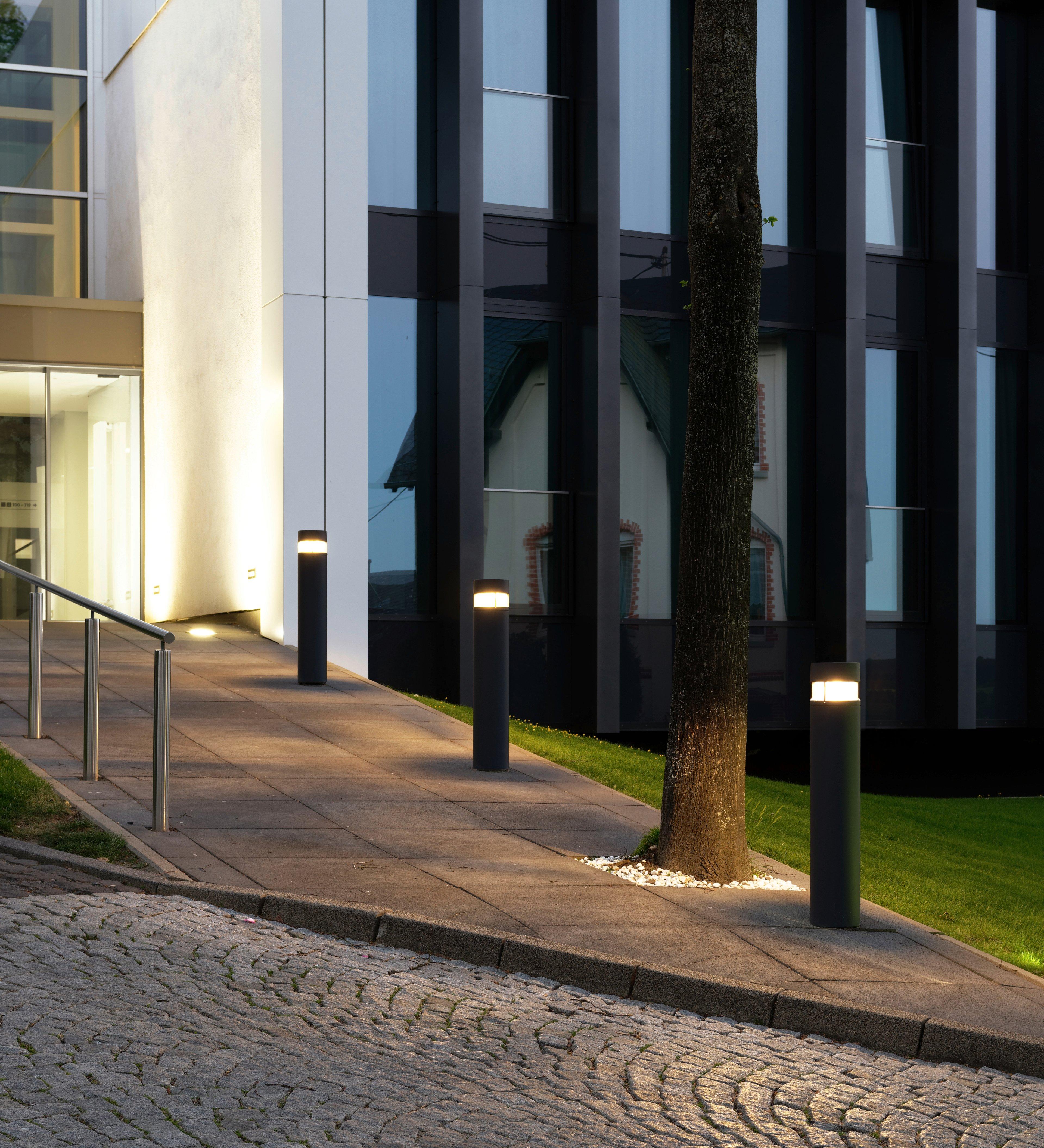 Architectural bollard lights installed along a contemporary landscape pathway.