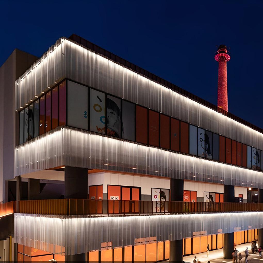 Linear wall washers providing uniform illumination across a contemporary retail façade.
