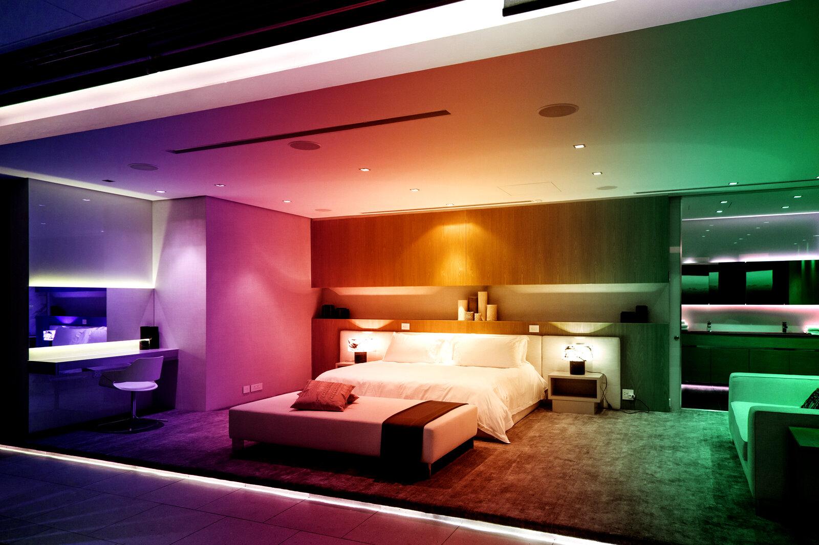 RGBW LED strips creating dynamic and warm ambient lighting in a contemporary hospitality interior.