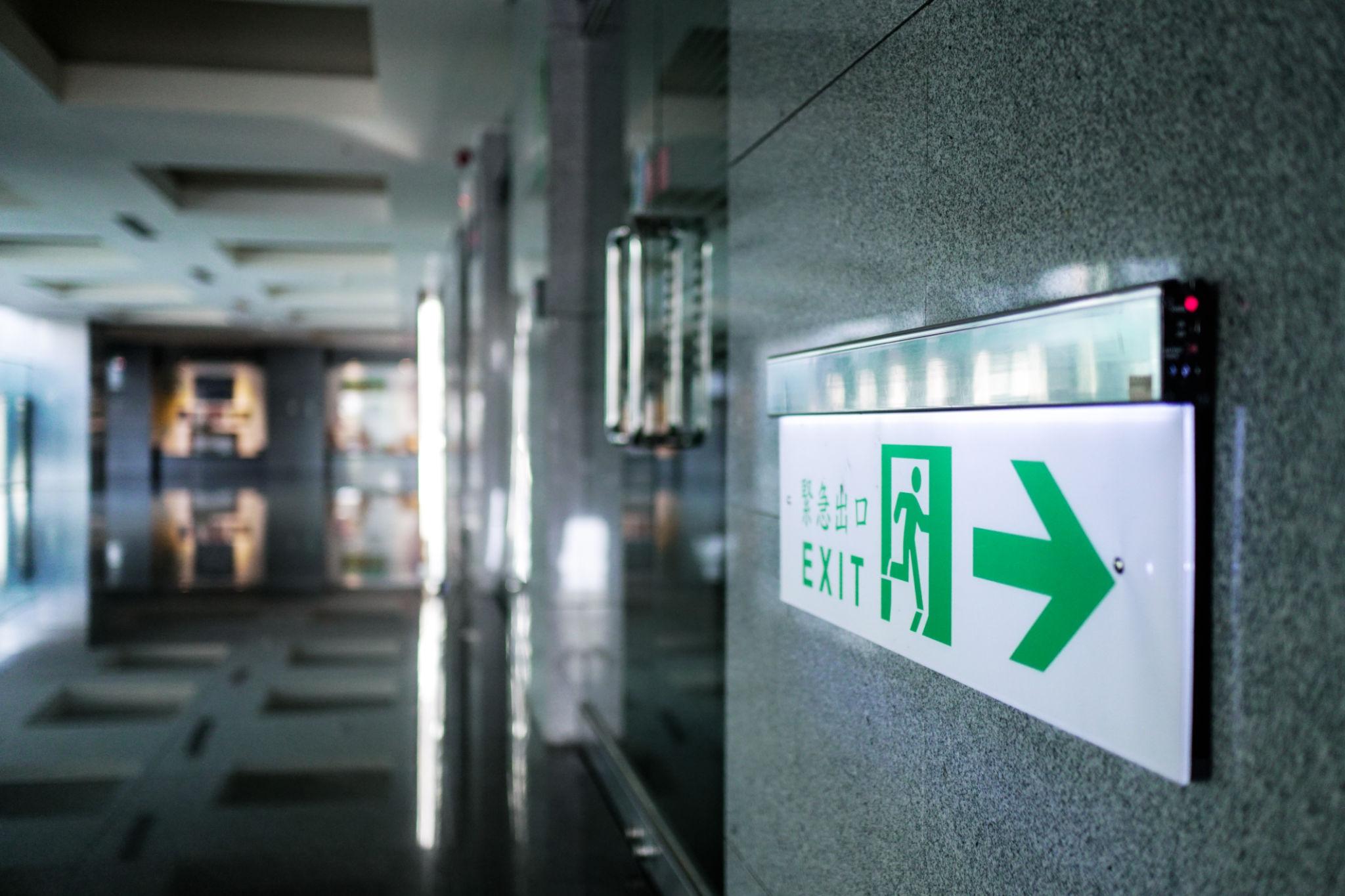 Wall-mounted exit signs installed in a contemporary public interior.