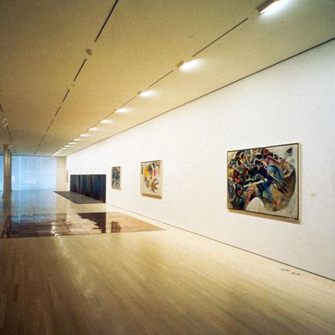 Adjustable recessed wall washer illuminating artwork in a contemporary gallery.