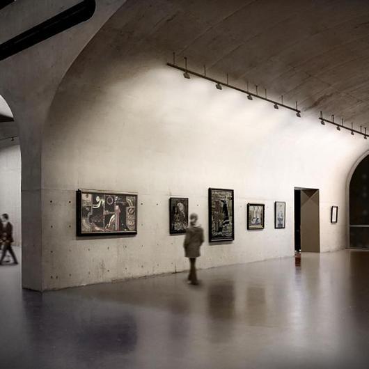 Adjustable recessed wall washer illuminating artwork in a contemporary gallery.