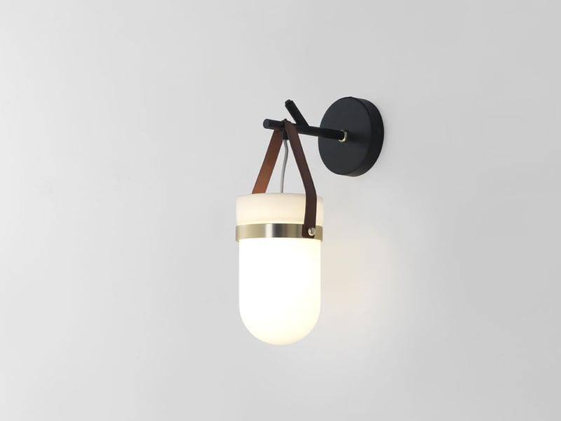 Front view of a bedside wall lamp with integrated reading light and refined finish.