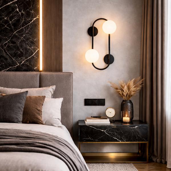 Bedside wall lamp installed beside a luxury hotel bed providing warm ambient illumination.