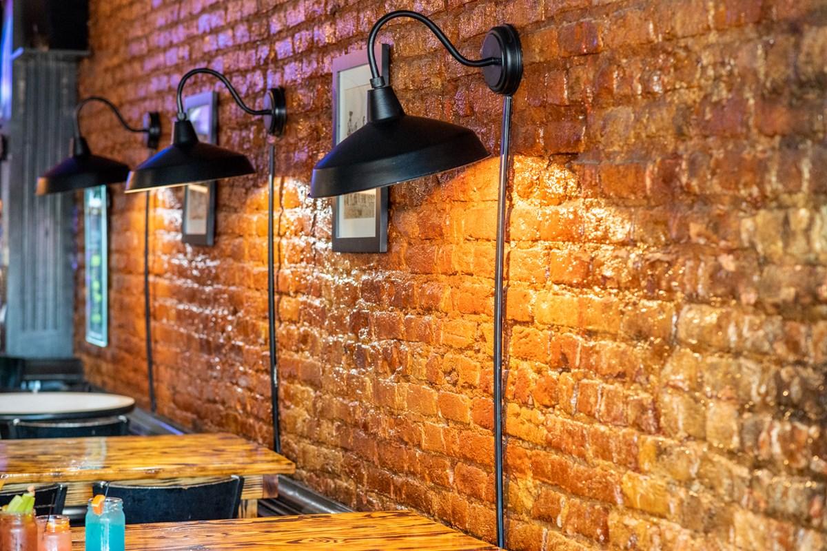 Industrial wall lamp installed in a contemporary restaurant with industrial architectural styling.