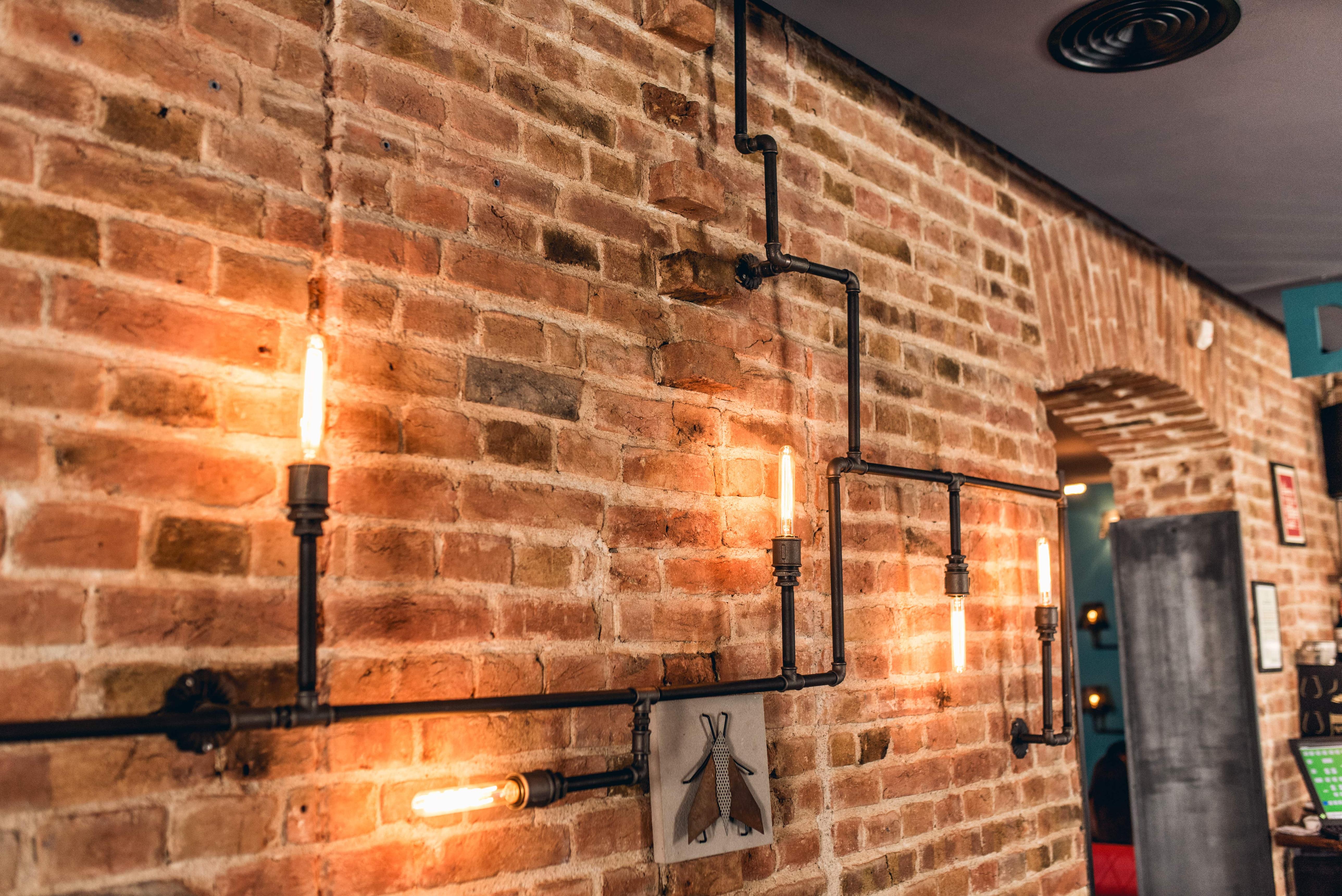 Industrial wall lamp installed in a contemporary restaurant with industrial architectural styling.