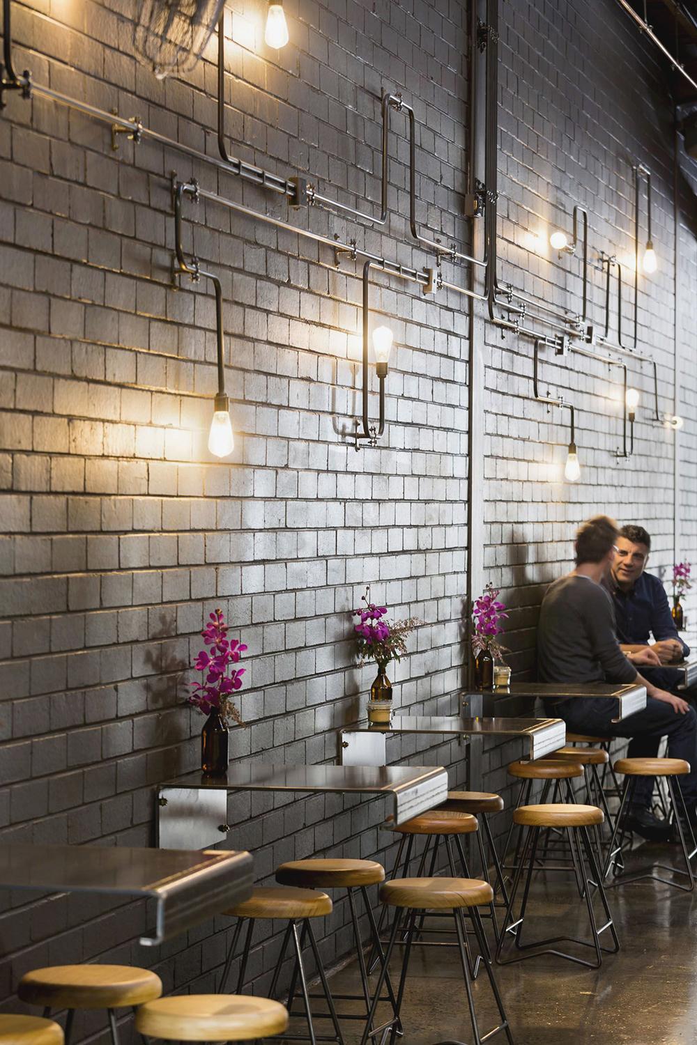 Industrial wall lamp installed in a contemporary restaurant with industrial architectural styling.