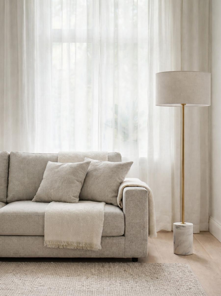 Marble floor lamp positioned beside a seating area in a luxury hotel lounge creating warm ambient lighting and timeless architectural elegance.