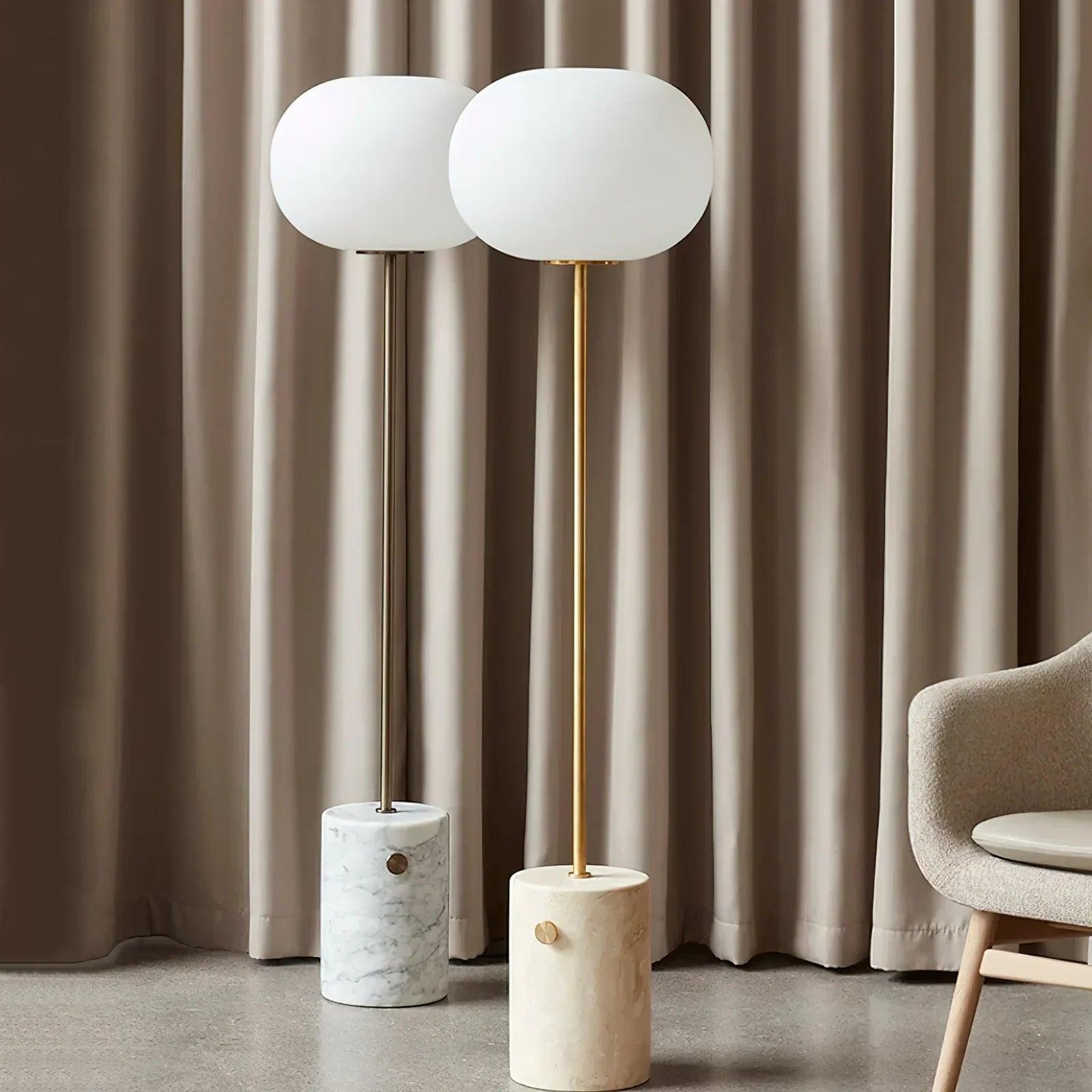 Marble floor lamp positioned beside a seating area in a luxury hotel lounge creating warm ambient lighting and timeless architectural elegance.