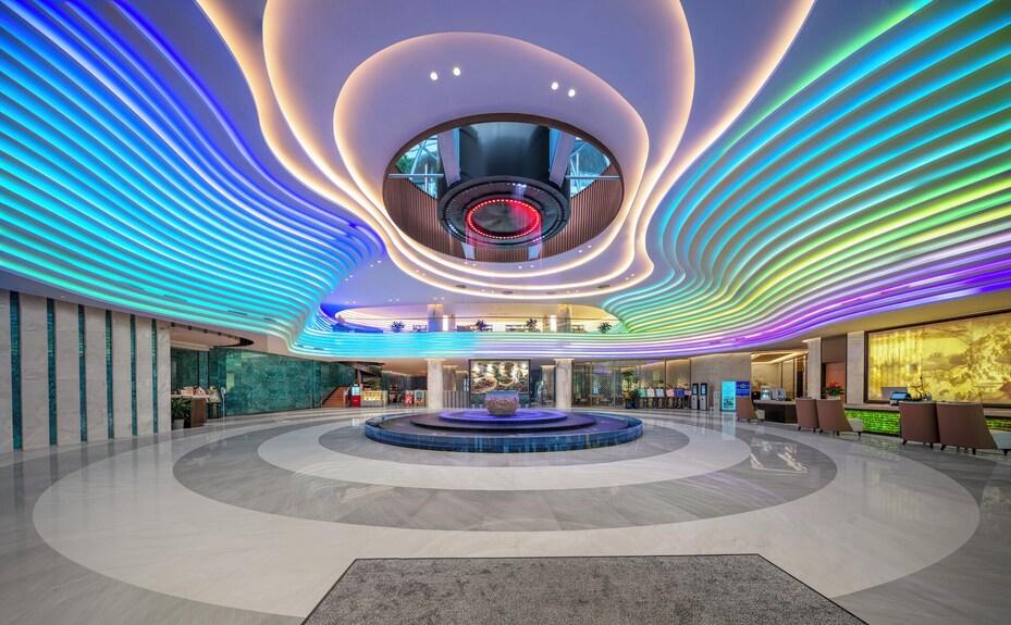 RGB cove lighting creating dynamic color-changing indirect illumination in a contemporary hospitality interior.